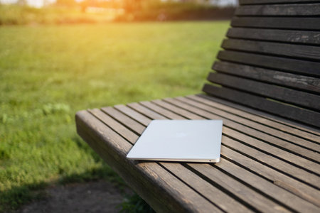 Laptop and nature. Laptop on a wooden table surrounded by forest. Close-up. High quality photoの写真素材