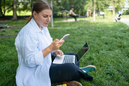 Young Caucasian student freelancer woman rest use laptop pc computer talk by mobile cell phone look,...