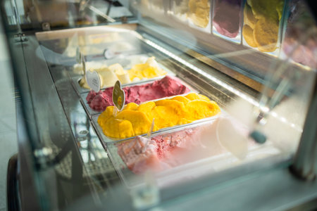 Display window in a store or ice cream parlour of assorted ice cream flavors for sale as summer takeaways displayed in metal trays. High quality photoの写真素材