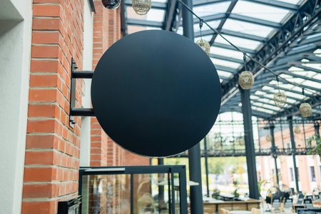 Mock up of blank signboard. Place for text, outdoor advertising, banner. Blank blue round store signboard mockup. Empty black illuminated shop lightbox template mounted on wallの写真素材