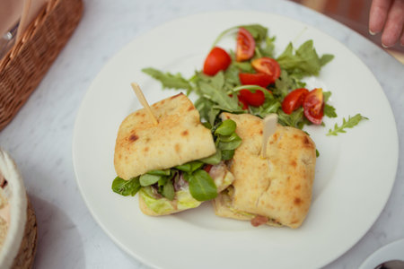 Healthy chicken and spinach sandwiches and fresh vegetable salad on the table at city cafe. Healthy...