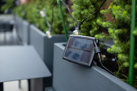Small solar powered led light s connected to a street decor garland at an urban cafe. High quality photoの写真素材