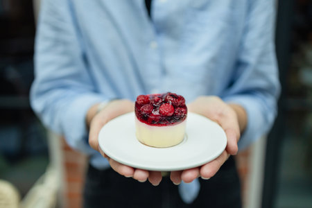 Woman holding birthday berry organic healthy vegetarianÂ  cake against blurred background, closeup. Space for text. High quality photoの写真素材