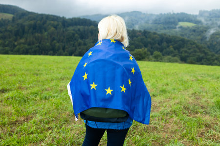 Woman with waving european union flag on a mountain background.. High quality photoの写真素材