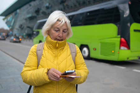 Tourist is waiting a taxi. Senior woman stand outside airport and wait for taxi cab after vacation...