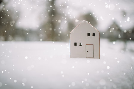Merry Christmas and 2024 happy new year banner with small toy model house on a white snow background. Miniature white toy house model . High quality photoの写真素材
