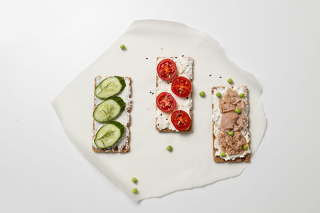 Ingredients for sandwich with boiled egg, cherry tomatoes, canned tuna, garlic and spices on grey...