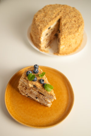 Homemade baked cake Napoleon, Millefeuille. Delicate custard cake garnished with berries and mint. On a gray concrete stone background. High quality photoの写真素材