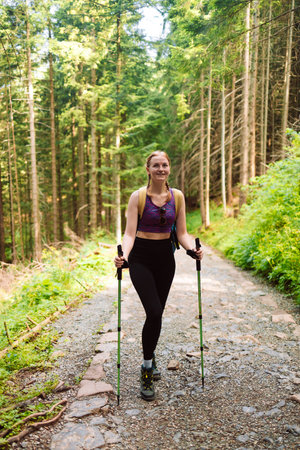 Happy woman traveler standing on the rock enjoying beautiful forest view.Female relaxing on hiking trip. Poland, Tatry, Zakopaneの写真素材