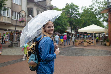 portrait of a girl walks in the autumn city under an umbrella. High quality photoの写真素材