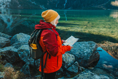 Shot of a senior 60s lost woman with smart phone holding a map while taking in the view from the top...