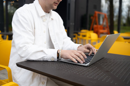 Happy successful European businessman makes a phone call on smartphone, talking and smiling outdoors sits at city cafe on city street outside. High quality FullHD footageの写真素材