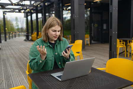 Happy successful European businessman makes a phone call on smartphone, talking and smiling outdoors sits at city cafe on city street outside. High quality FullHD footageの写真素材
