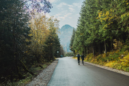 Autumn hike group of tourists on vacation, having a hike in autumn mountains with backpack and hiking sticks, enjoying adventure. Teamwork travel. Tatra National Park in Poland. Famous mountains lake Morskie oko or sea eye lake In High Tatrasの写真素材