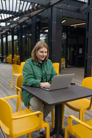 Happy successful European businessman makes a phone call on smartphone, talking and smiling outdoors sits at city cafe on city street outside. High quality FullHD footageの写真素材
