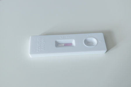 Caucasian woman using rapid antigen test kit for self test COVID-19 epidemic at home. Adult female unpacking a swab for inserts into her nose. COVID-19 coronavirus pandemic protection concept.の写真素材