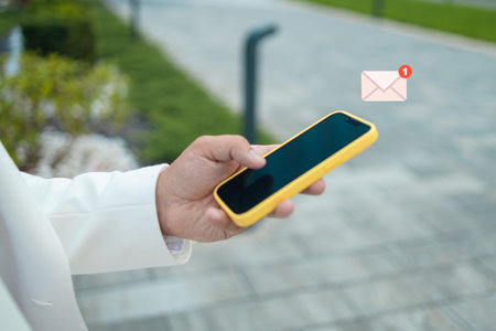 New messages on mobile phone, hands of businessman opening inbox to view the pending e-mail communication, copy space. High quality photoの写真素材