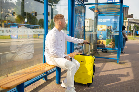 Tourist Caucasian business man traveler with bag and suitcase sit at public transport bus station...