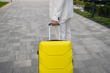 Close-up of male Caucasian hand holding travel bag. Unrecognizable young man arriving at hotel. Unknown client entering room with luggage. Travelling, tourism, business trip, lifestyle. High quality photoの写真素材