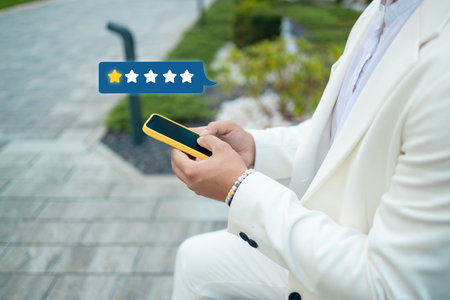 Customer satisfaction experience concept. Businessman using mobile phone giving one star icon and excellent for feedback review satisfaction service. rating very impressed. High quality photoの写真素材