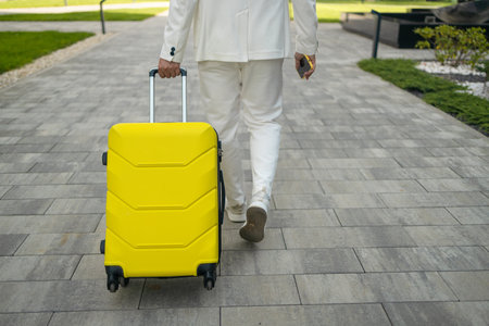 Close-up of male Caucasian hand holding travel bag. Unrecognizable young man arriving at hotel. Unknown client entering room with luggage. Travelling, tourism, business trip, lifestyle. High quality photoの写真素材