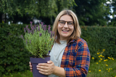 Happy woman farmer holding plastic box with fresh lavender flower herbs on countryside field. High quality photoの写真素材