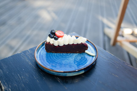Piece of delicious homemade chocolate cake with fresh berry on a beautiful plate at city cafe, desert with chocolate. High quality FullHD footageの写真素材