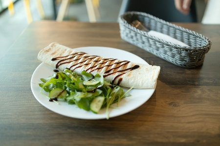 Tortilla wraps with chicken and fresh vegetables on white plate in cafe. Close up view. High quality photoの写真素材