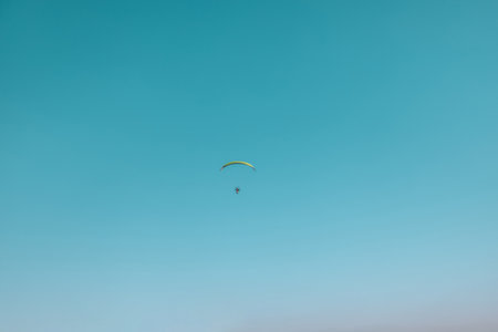Alone paraglider flying in the blue sky against the background of clouds. Paragliding in the sky on a sunny day. High qualityの写真素材