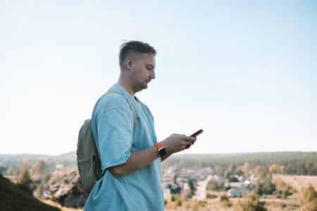Travel, map and Caucasian man pointing in city for adventure, holiday or directions in MIrow Castle, Poland. Tourist, young male with document for location, search destination or outdoor sightseeing. High quality photoの写真素材