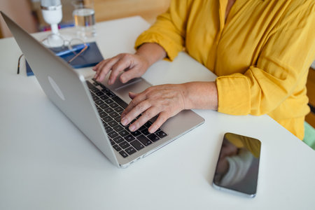 Overview of hands of young businesswoman or student typing on laptop keyboard by desk while working over presentation. High quality photoの写真素材