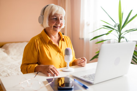 Female podcaster use smartphone and speaking with audience on microphone to recording video podcast. High quality photoの写真素材