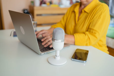 Female podcaster use smartphone and speaking with audience on microphone to recording video podcast....