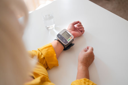 Close-up of wrist blood pressure monitor on female hand measuring pulse and blood pressure. Health care and check up concept.の写真素材