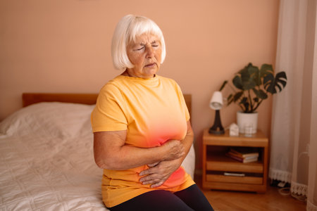Abdominal pain in elder senior mature aging woman with stomachache illness from stomach cancer, irritable bowel syndrome, Indigestion, Diarrhea, gastroparesis or GERDの写真素材
