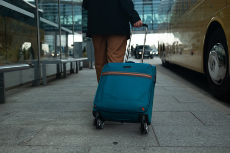 Airport Terminal: Businesswoman in casual clothing walks through an airport terminal with a large rolling suitcaseの写真素材