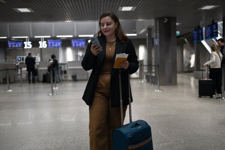 Portrait of Caucasian traveler woman hold ticket ready enjoy voyage tour passenger walk in airport terminal to boarding gate. Attractive beautiful female tourist excited to go travel abroad by airplane for holiday vacation trip.の写真素材