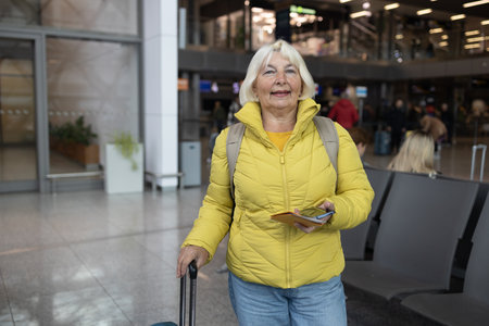 stylish pretty 50s woman traveling with suitcase in Europe in trend autumn outfit street style. High quality photoの写真素材
