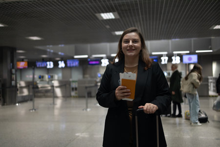 Portrait of Caucasian traveler woman hold ticket ready enjoy voyage tour passenger walk in airport terminal to boarding gate. Attractive beautiful female tourist excited to go travel abroad by airplane for holiday vacation trip.の写真素材