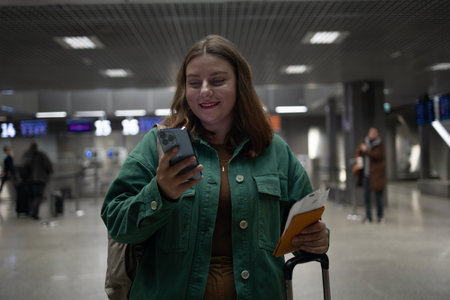International airport terminal. Happy attractive Caucasian 30s woman traveler with backpack at the modern airport terminal. Tourist journey trip conceptの写真素材