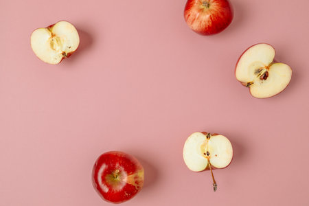 Green red apple, half apple and quarter apple on pink background. Top view, healthy food concept. Top view. High quality photoの写真素材