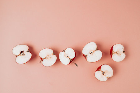 Green red apple, half apple and quarter apple on pink background. Top view, healthy food concept.の写真素材