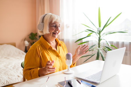 Female podcaster use smartphone and speaking with audience on microphone to recording video podcast. High quality photoの写真素材