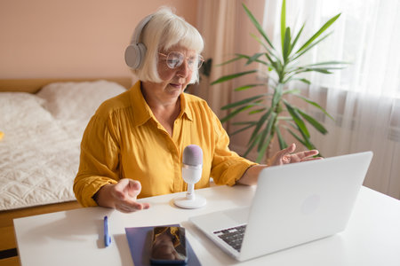 Female podcaster use smartphone and speaking with audience on microphone to recording video podcast. High quality photoの写真素材
