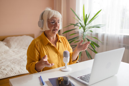 Female podcaster use smartphone and speaking with audience on microphone to recording video podcast. High quality photoの写真素材