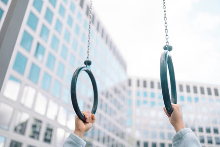 Hands, gymnastics ring and person in fitness for workout, strength training or competition. Closeup of hanging athlete, strong gymnast or acrobat holding on balance circles for performance exercise. High quality photoの写真素材