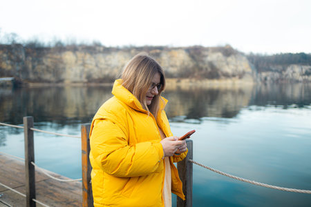 Young caucasian woman sending message using smartphone annoyed and frustrated with raised hand