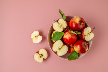 Bowl with fresh red apples on pink background. Harvesting apples.Top view, flat lay, copy space.の写真素材