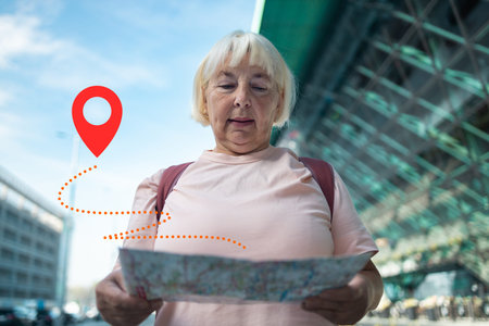 An elderly woman is navigating the airport area with a map in hand, looking for her next...