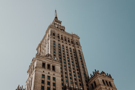 Low angle view of a monumental skyscraper with neoclassical architectural details under a clear blue sky. The building spire and symmetrical design emphasize its grand scale and historic significance.の写真素材